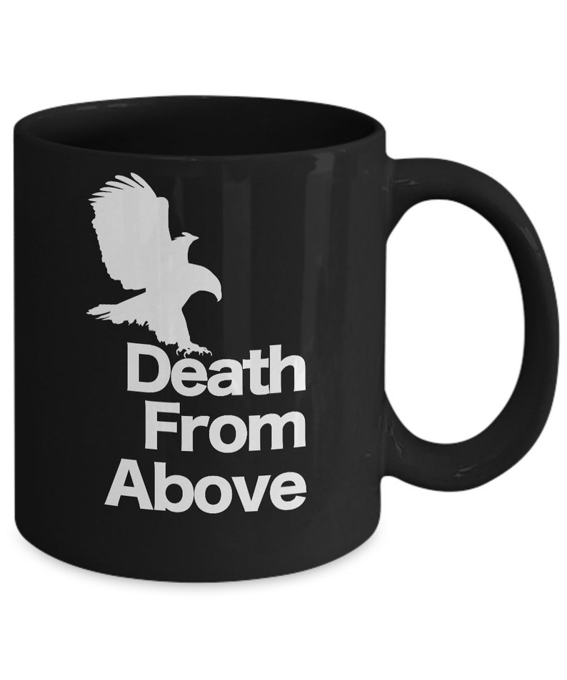 以下が含まれることがあります： 白い鷲のシルエットと「Death From Above」という文字が書かれた黒いセラミック製のコーヒーカップです。
