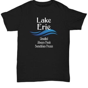 May include: Black t-shirt with a white graphic design that says "Lake Erie" with a blue wave design underneath. The text below the wave says "Unsalted Always Fresh Sometimes Frozen".