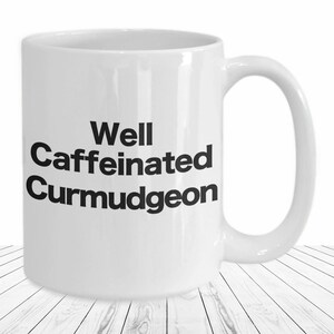 May include: White ceramic coffee mug with black text that reads "Well Caffeinated Curmudgeon".