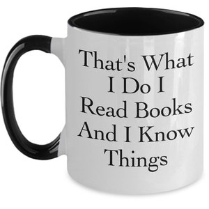 May include: White ceramic coffee mug with a black interior and handle. The mug has black text that reads "That's What I Do I Read Books And I Know Things."