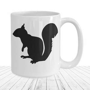 May include: White ceramic mug with a black silhouette of a squirrel on the front.