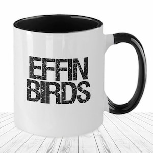 May include: White coffee mug with a black interior and handle. The mug has a black and white distressed graphic that says "Effin Birds".