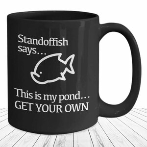 May include: Black coffee mug with white text that reads "Standoffish says... This is my pond... GET YOUR OWN" and a white cartoon fish illustration.