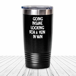 May include: Black stainless steel tumbler with a white inscription that reads "Going Insane Looking For A Vein In Vain".