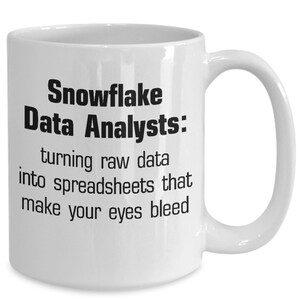 May include: White ceramic coffee mug with black text that reads "Snowflake Data Analysts: turning raw data into spreadsheets that make your eyes bleed."