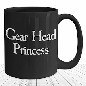 May include: Black ceramic coffee mug with white text that reads "Gear Head Princess".