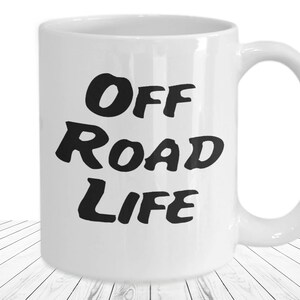 May include: White ceramic mug with the words "Off Road Life" in bold black letters. The mug has a curved handle and is set against a white background.