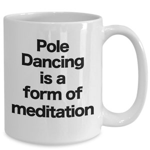 May include: White ceramic coffee mug with black text that reads "Pole Dancing is a form of meditation."