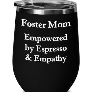 May include: Black stainless steel wine tumbler with white text that reads "Foster Mom Empowered by Espresso & Empathy".