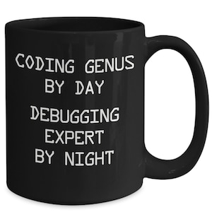 May include: Black coffee mug with white text that reads "Coding Genius by Day Debugging Expert by Night".