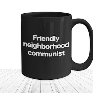 May include: Black coffee mug with white text that reads "Friendly neighborhood communist".