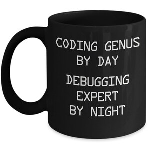 May include: Black coffee mug with white text that reads "Coding Genius by Day Debugging Expert by Night".