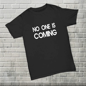 May include: Black t-shirt with white text that reads "NO ONE IS COMING".