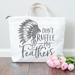 May include: White canvas tote bag with a gray graphic of a Native American headdress and the text "Don't ruffle my feathers".