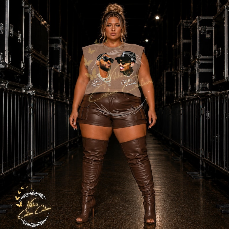May include: A woman wearing a brown sleeveless top with a graphic of two men, brown leather shorts, and brown thigh-high boots. The top has a crew neck and the shorts have pockets. The boots have a stiletto heel.