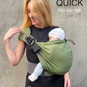 May include: Green hip carrier with the text "QUICK hip carrier". The carrier is being worn by a person and is holding a baby. The carrier has a black buckle and a gray waist belt.