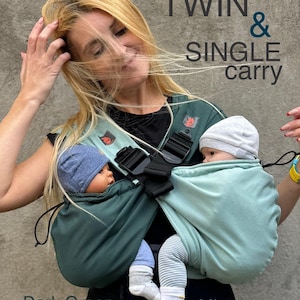 Könnte beinhalten: Ein dunkelgrüner und mintfarbener Babyträger für Zwillinge oder ein einzelnes Kind. Er verfügt über verstellbare Träger und einen Schnallenverschluss. Der Text "TWIN & SINGLE carry" ist zu sehen. Die Wörter "Dark Green" und "Mint" sind ebenfalls sichtbar.