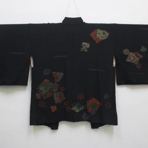 May include: A black Japanese kimono with colorful geometric patterns. The kimono has long sleeves and a wide collar.