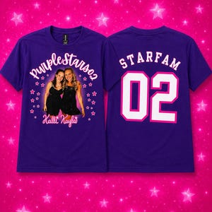 Peut inclure: Un t-shirt violet avec un graphisme frontal montrant une photographie de deux personnes en robes noires, entourées d'étoiles roses et du texte "Purplestars02" et "Kalli Kayla". Le dos affiche le texte "STARFAM" au-dessus du grand nombre "02".