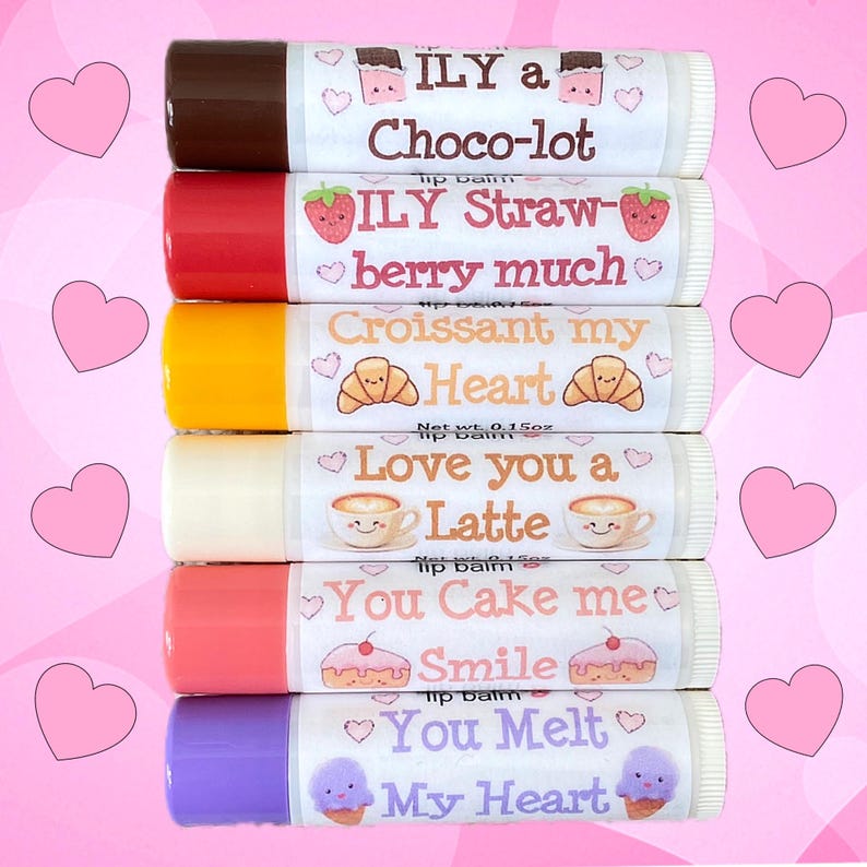 May include: A stack of six lip balm tubes with different flavors and messages. The lip balms are all white with colorful labels. The labels have different designs and messages, including 'ILY a Choco-lot', 'ILY Straw-berry much', 'Croissant my Heart', 'Love you a Latte', 'You Cake me Smile', and 'You Melt My Heart'.