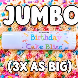 May include: A cylindrical lip balm tube labeled Birthday Cake Bliss with a white cap and a label featuring colorful confetti patterns. The product is positioned against a background of cake with frosting and multi-colored star sprinkles.