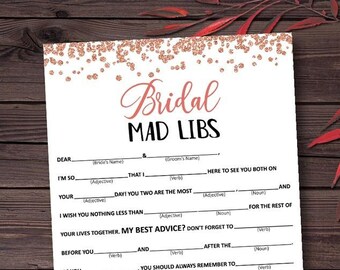 Op de afbeelding: Een printbaar bruiloft mad libs-spel met een roze gouden glitterachtergrond. Het spel bevat zinnen met lege plekken over de bruid en bruidegom.