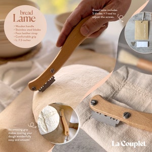 May include: Bread lame with a wooden handle, stainless steel blades, and a faux leather strap. The blade is 7.5 inches long. The image shows the bread lame with a loaf of bread and flour.
