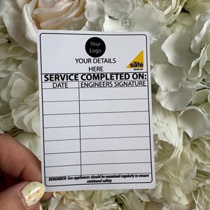 May include: White card with black text that reads "Your Logo" and "Your Details Here". The card also has a yellow sticker with the text "Gas Safe Register" and the words "Service Completed On:" with spaces for the date and engineer's signature.