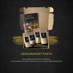 Könnte beinhalten: Eine braune Geschenkschachtel aus Pappe mit offenem Deckel, die sechs kleine braune Papiertüten mit Etiketten für verschiedene Pastasaucen enthüllt. Die Schachtel enthält auch ein kleines Kochbuch mit einem Foto von Pasta auf dem Cover. Der Text auf der Schachtel lautet "Geschenkset Pasta" und "Das perfekte Geschenk für Pastafans. Geschenkbox mit sechs Gewürzen und unserem Pasta Rezeptheft."