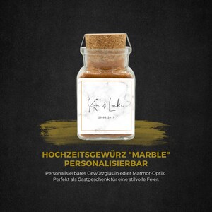 Könnte beinhalten: Ein klares Glasgefäß mit einem Korkverschluss, gefüllt mit braunem Gewürz. Das Gefäß hat ein weißes Etikett mit Marmor-Muster und dem Text "Kim & Luke 23.01.2019". Der Text "Hochzeitsgewürz "Marble" Personalisierbar" befindet sich unter dem Gefäß. Der Text "Personalisierbares Gewürzglas in edler Marmor-Optik. Perfekt als Gastgeschenk für eine stilvolle Feier." befindet sich unter dem Text.