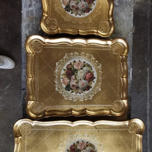 K&ouml;nnte beinhalten: Drei verzierte, goldfarbene Serviertabletts. Jedes Tablett hat einen gewellten Rand und ein Blumenzentrum mit roten, rosa und wei&szlig;en Rosen. Die Tabletts sind ineinander verschachtelt.