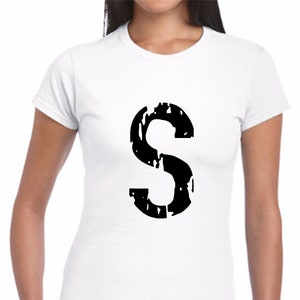 May include: White t-shirt with a black distressed letter "S" printed on the front.