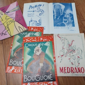 Peut inclure: Une collection d'affiches de cirque vintage avec le nom "Medrano" et des illustrations de clowns, de chevaux et d'autres artistes de cirque. Les affiches sont en français et comportent les textes "Cirque d'Hiver" et "Bouglione".