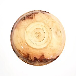 May include: A wooden bowl with a natural wood finish. The bowl has a unique grain pattern and is signed "B.L. White" on the bottom.