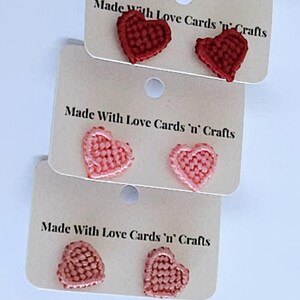 May include: Image of three pairs of heart-shaped earrings in red and pink hues. Each pair is presented on a small card with the text "Made With Love Cards 'n' Crafts". The earrings are likely handmade.