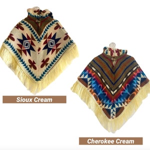 K&ouml;nnte beinhalten: Zwei dreieckige Ponchos mit Fransen, einer in Creme mit roten, blauen und braunen geometrischen Mustern, beschriftet "Sioux Cream", und der andere in Braun mit roten, blauen und wei&szlig;en geometrischen Mustern, beschriftet "Cherokee Cream".