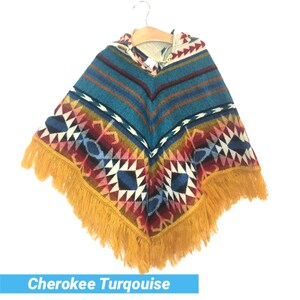 K&ouml;nnte beinhalten: Ein t&uuml;rkisfarbenes, rot, gelb und wei&szlig; gemustertes Poncho mit Kapuze und gelbem Fransenbesatz. Das Poncho tr&auml;gt den Text "Cherokee Turquoise" darunter.