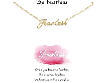 May include: A gold-colored necklace with the word "Fearless" in cursive script. The image also includes the text "Be Fearless" and a watercolor-style pink background with the word "Fearless" in white. Additional text reads: "Once you become fearless, life becomes limitless."