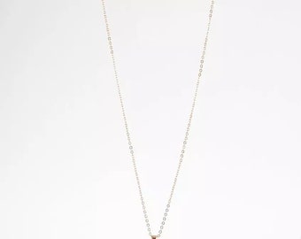 May include: A gold chain necklace with a round pendant featuring an intricate design.