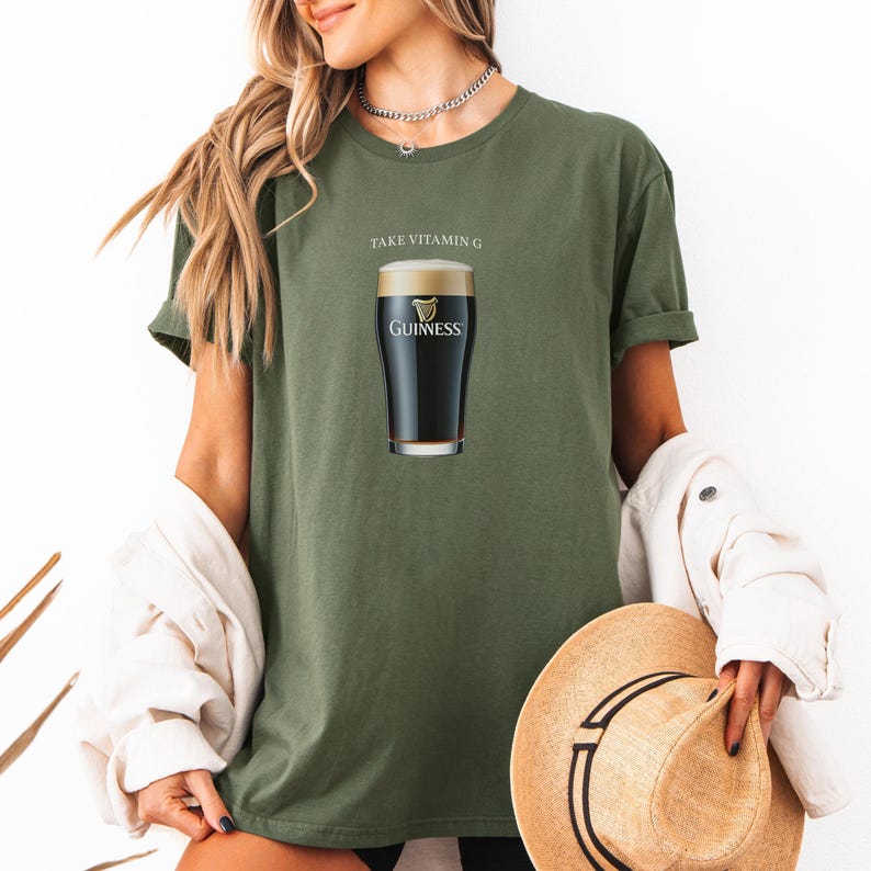 Puede incluir: Una camiseta verde con el texto "Take Vitamin G" y un gr&aacute;fico de un vaso de cerveza Guinness.