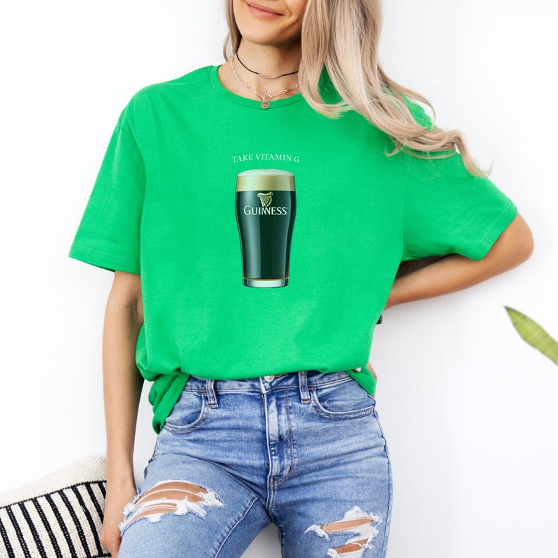 Puede incluir: Camiseta verde con el texto "Take Vitamin G" y un gr&aacute;fico de un vaso de cerveza Guinness.