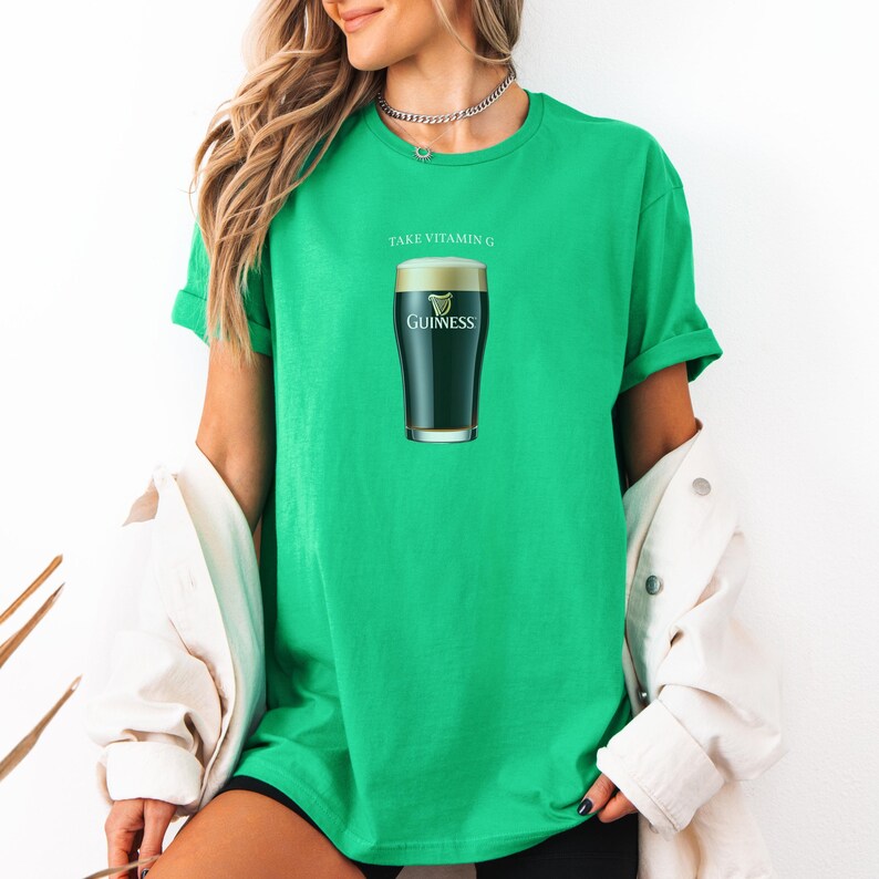 Puede incluir: Una camiseta verde con el texto "Take Vitamin G" y un gr&aacute;fico de un vaso de cerveza Guinness.
