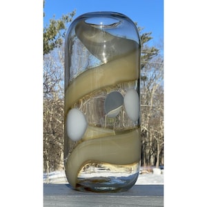 May include: A clear glass vase with a swirl of beige glass and white and gray circles.