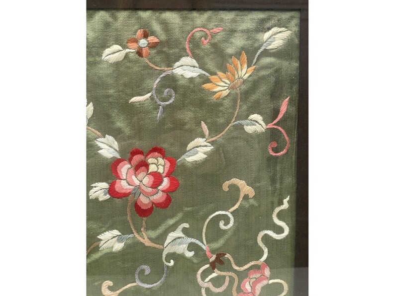 May include: A framed green silk embroidery with floral designs in shades of pink, red, white, and yellow. The embroidery features delicate flowers and leaves.