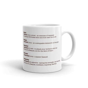 May include: White ceramic mug with a brown text design that defines the word "Squats" and its variations. The text reads: "Squats (skwots) noun, plural - an exercise of repeated crouching, with knees bent and butt near the heels. Sasquat (sas-kwet) noun - an unstoppable behemoth in the gym. Squatin (sas-kwot-in) verb - to attack your workout with the ferocity of a Sasquat; not for the faint of heart. Lus-quat (sas-kwot) noun - a sassier Sasquat. Sasquatchy (sas-kwoch-ee) adjective - having the strength, the bearing and drive of a Sasquat; confident; imposing; fearless."