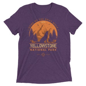 May include: Purple t-shirt with a vintage-style graphic of a wolf howling at the moon in front of a mountain range. The graphic says "Home of the Gray Wolf, Yellowstone National Park, 1872".