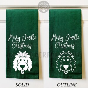 Puede incluir: Dos toallas de cocina verdes con el texto "Merry Doodle Christmas!" y un garabato de la cara de un perro. Una toalla tiene la cara del perro s&oacute;lida y la otra tiene el contorno de la cara del perro.