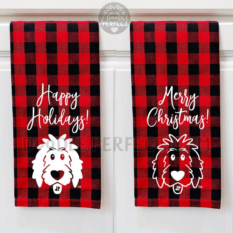Puede incluir: Dos toallas de cocina de cuadros rojos y negros con ilustraciones de perros doodle blancos y saludos navide&ntilde;os. La toalla de la izquierda dice "&iexcl;Felices Fiestas!" y la toalla de la derecha dice "&iexcl;Feliz Navidad!"