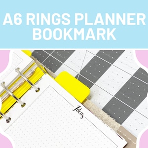 Op de afbeelding: A6 Rings Planner Bookmark met de tekst "A6 Rings Planner Bookmark" in het wit. De afbeelding toont een planner met gele tabbladen en een grijs en wit patroon. De planner is open op een pagina met het woord "Ideas" erop.