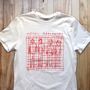 May include: White t-shirt with a red graphic of five stick figures in a grid with the text "TÊTES PARLANTES" above them. The text "LES BACCHUS" is printed in smaller font below the graphic.